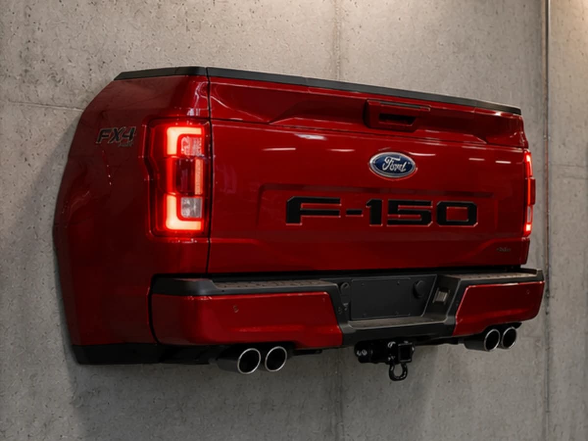 Crimson X deep red automotive wall sculpture installed on a concrete garage wall