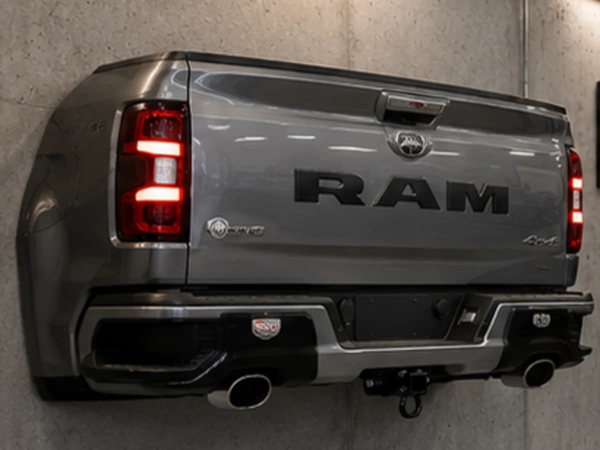 Gunmetal L smoke grey automotive wall sculpture installed on a concrete garage wall