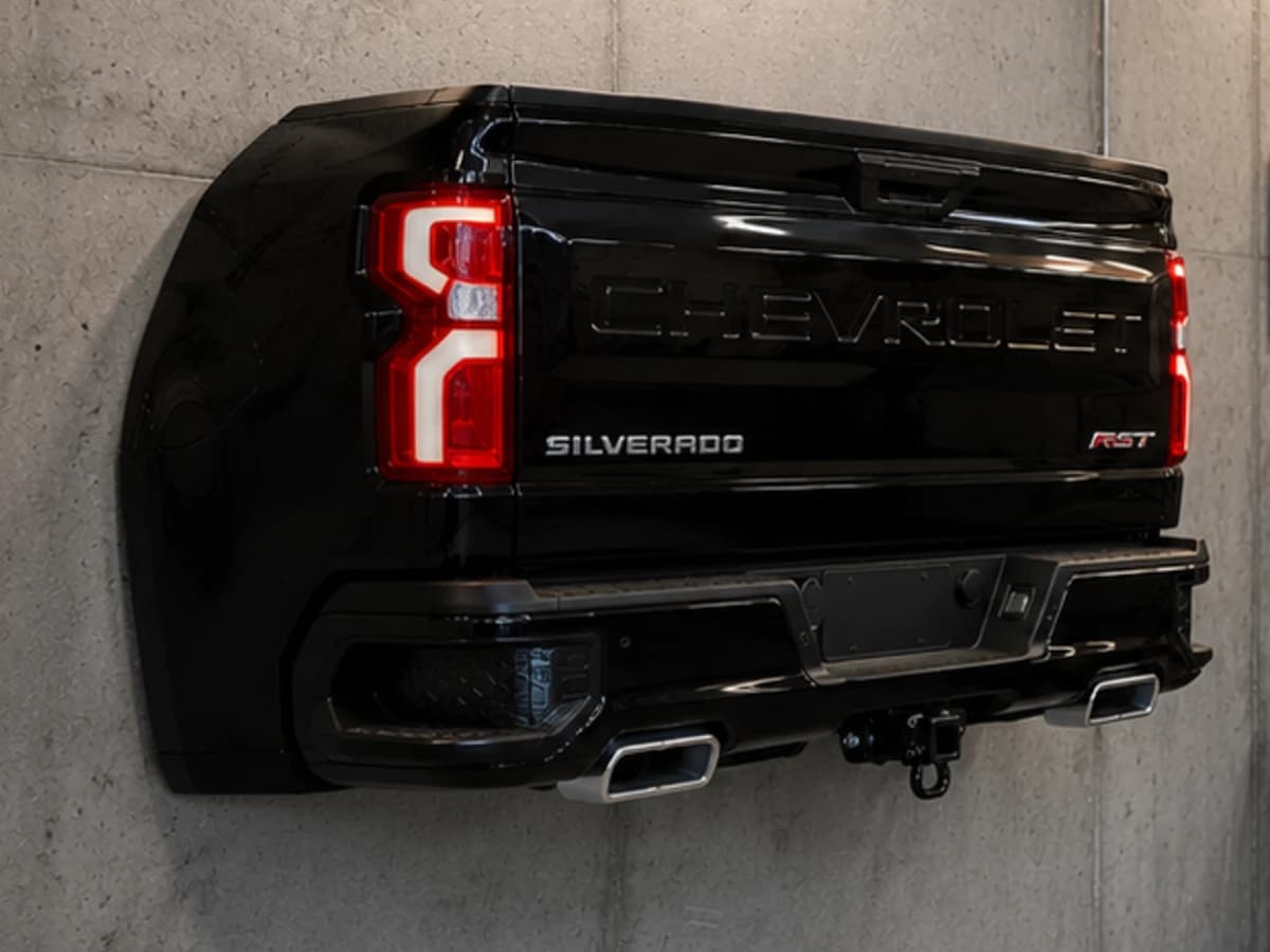 Obsidian R gloss black automotive wall sculpture installed on a concrete garage wall